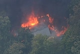 A house in flames from a helicopter in the Bunyip fire.