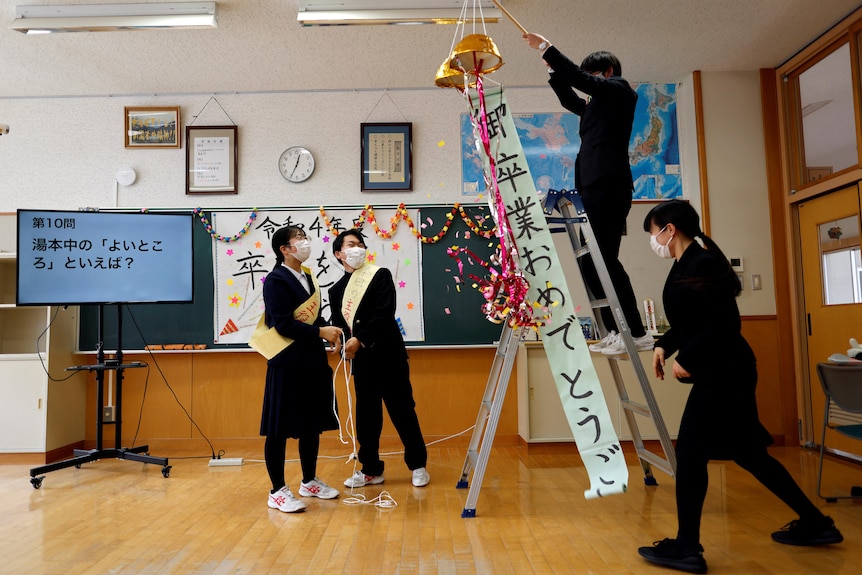 Teachers at Yumoto Junior High School hold a special ceremony in their classroom for the final two graduating students