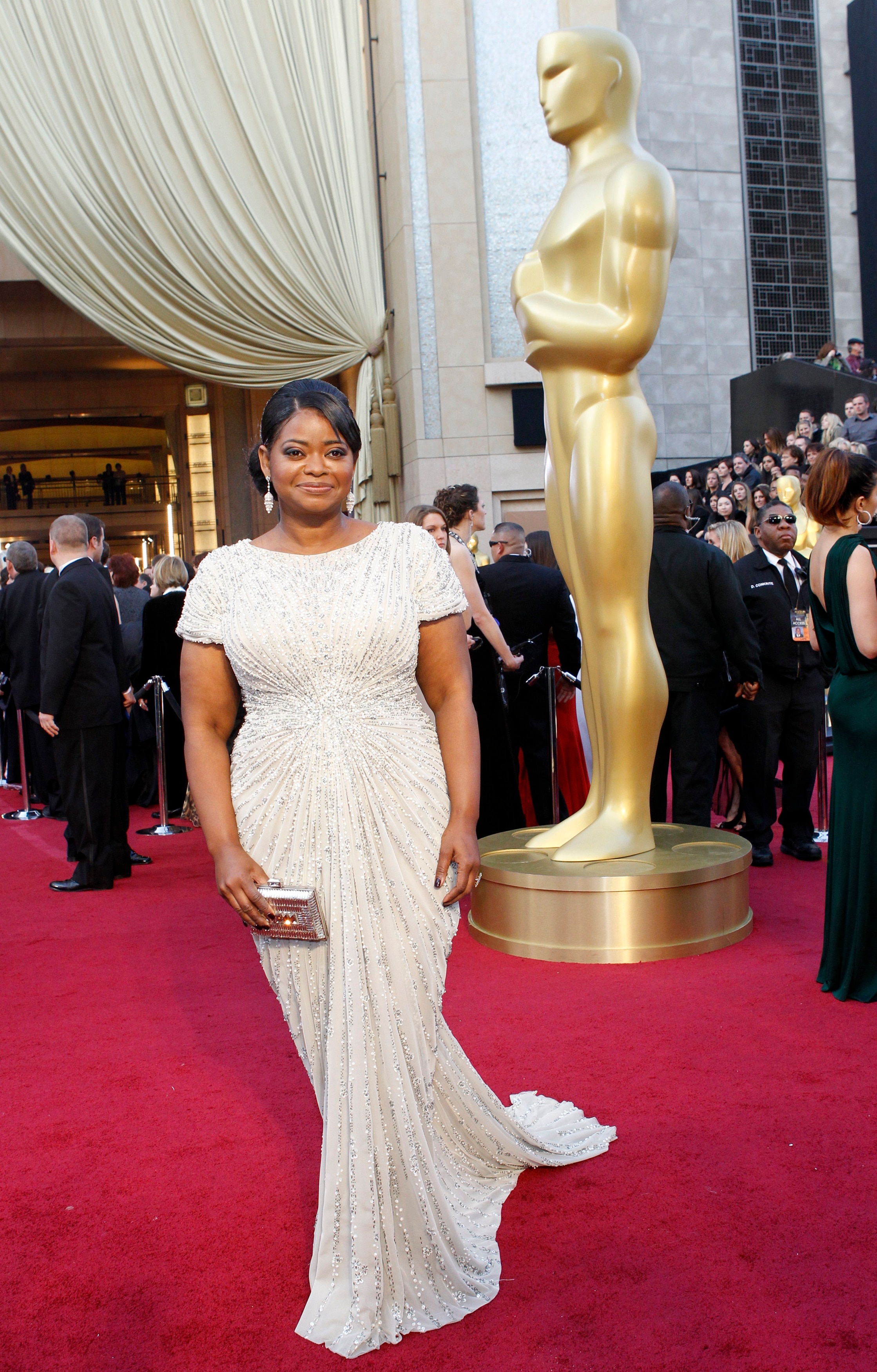 Octavia Spencer wearing a white sparkly gown with t-shirt-like sleeves and a long train