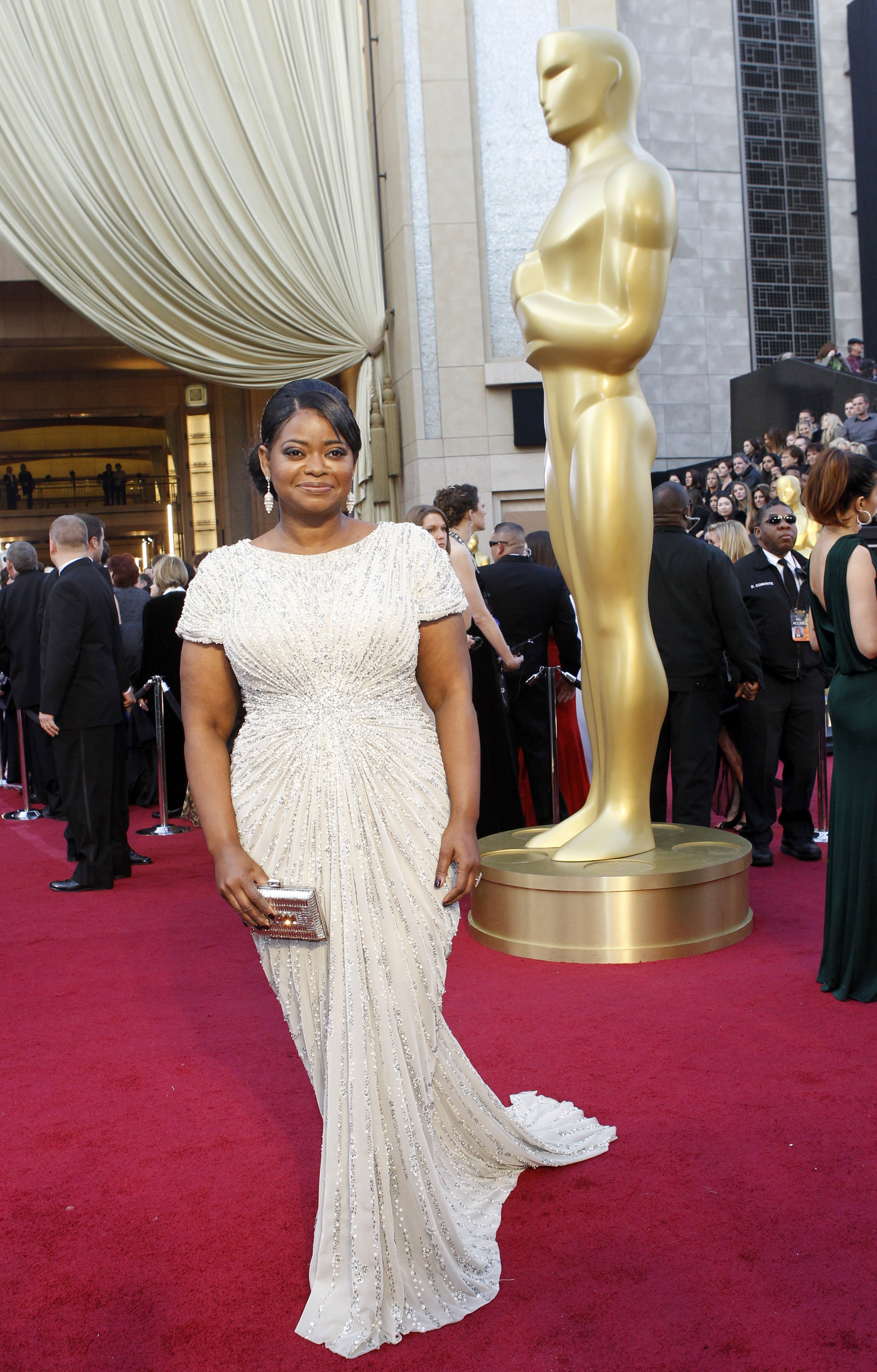 Octavia Spencer wearing a white sparkly gown with t-shirt-like sleeves and a long train