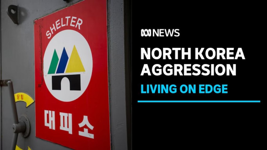 North Korea Aggression, Living on Edge: A red sign on a grey door with text on it reading Shelter and Korean characters