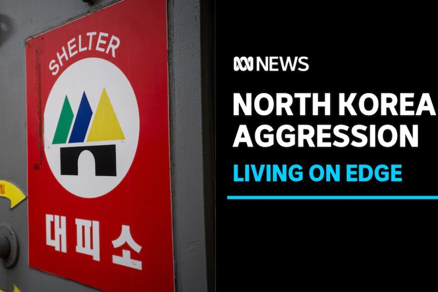 North Korea Aggression, Living on Edge: A red sign on a grey door with text on it reading Shelter and Korean characters