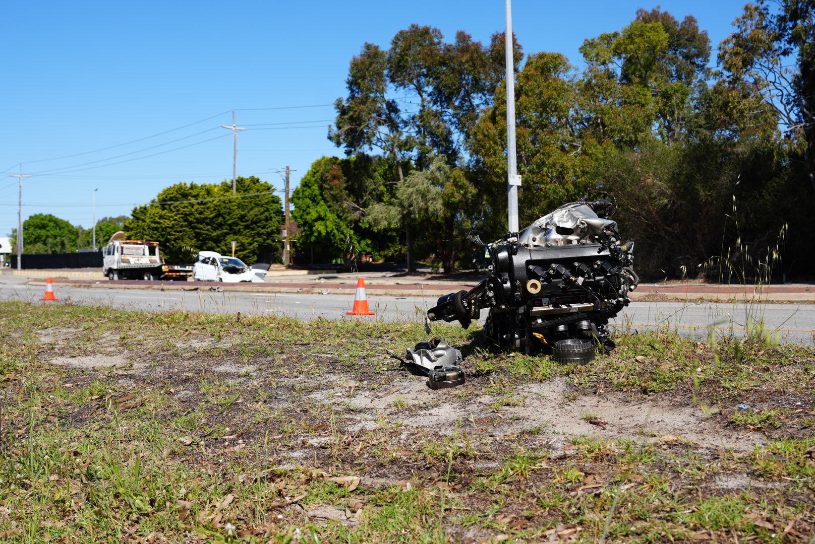 A car's engine lies by the side of the road