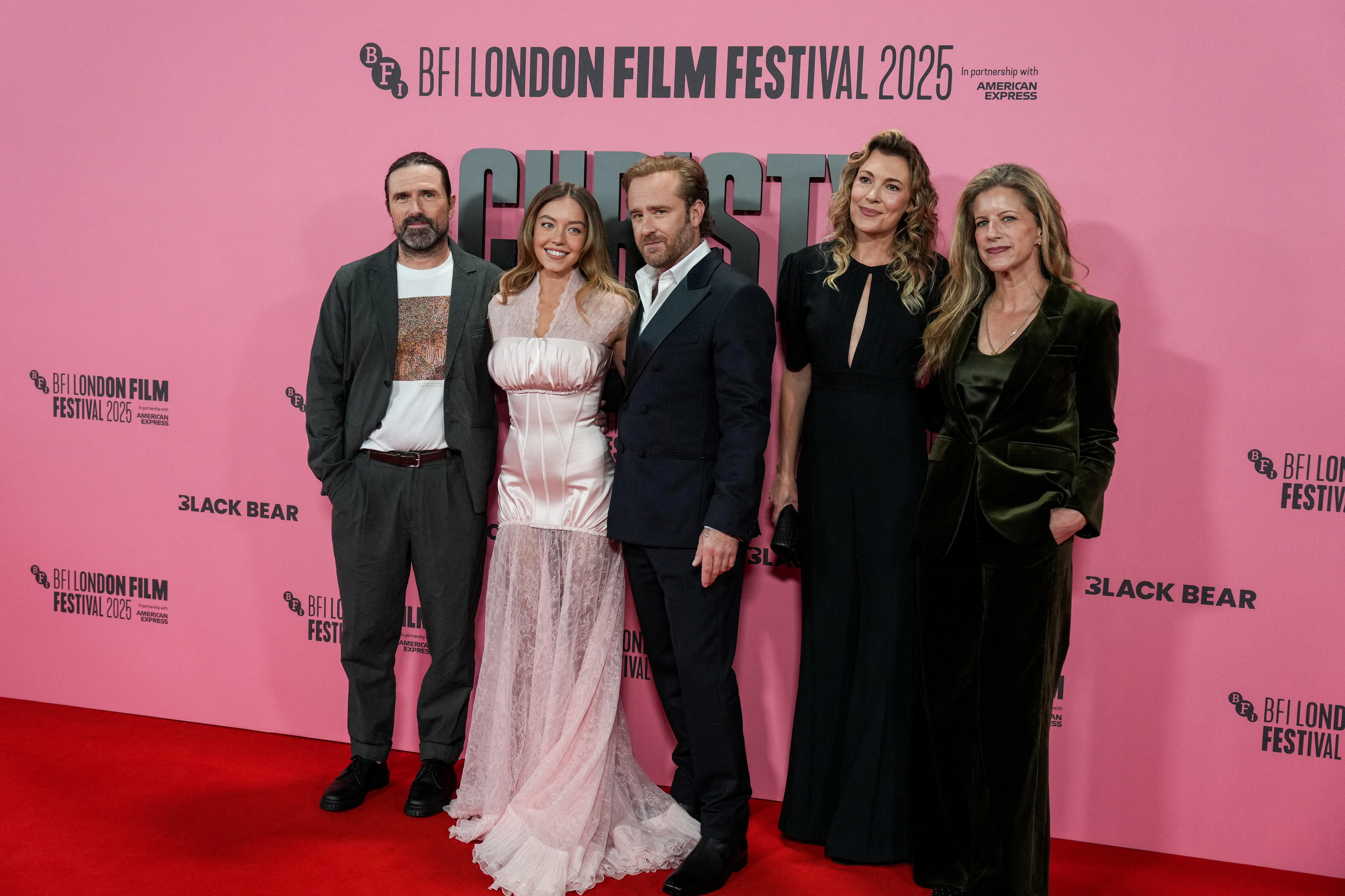 Three women and two men on the red carpet at a film premiere.