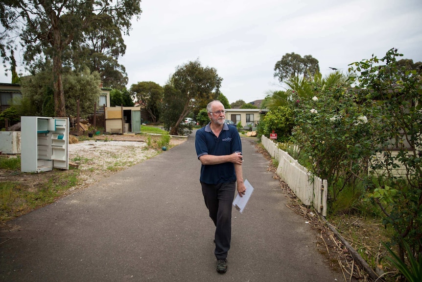 Peter Gray strides among discarded fridges and vacant lots, keeping a record of who has left and who remains.