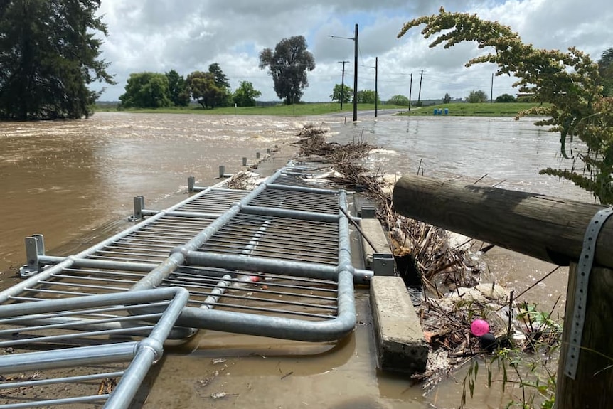 Floodwater rushing over a bridge.