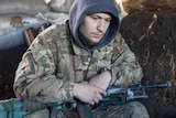 An Ukraine soldier holds a gun.