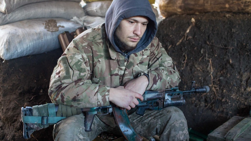 An Ukraine soldier holds a gun.