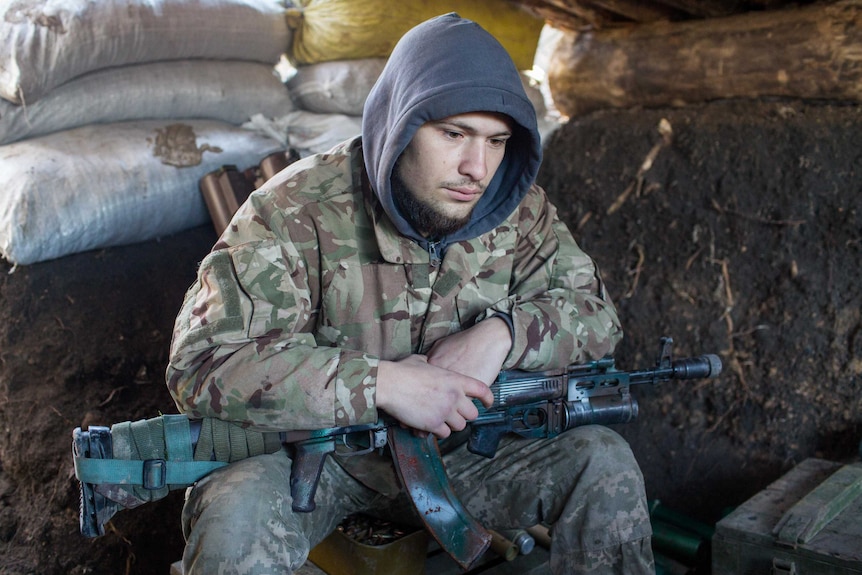 An Ukraine soldier holds a gun.