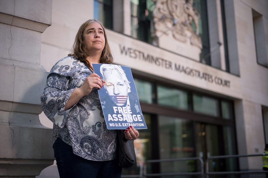 Emmy Butlin stands outside Westminster Magistrates Court holds a poster saying Free Assange