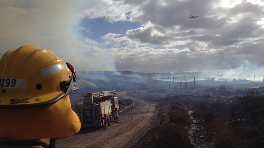 Firefighter looks on as crews fight fire