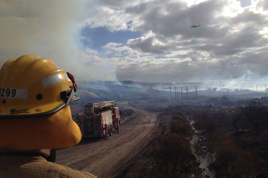 Firefighter looks on as crews fight fire