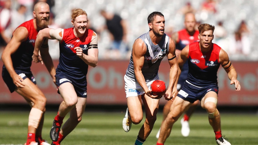 Port Adelaide's Travis Boak looks to handpass the ball under pressure against Melbourne
