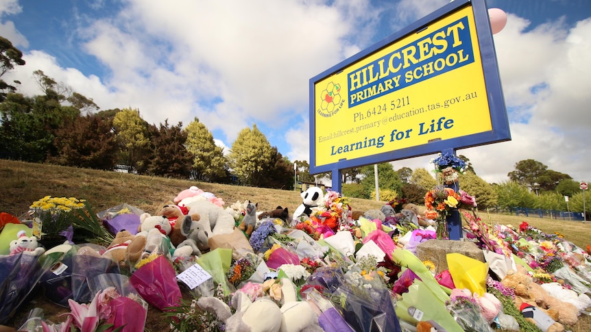 Bunches of flowers under a sign reading: Hillcrest Primary School