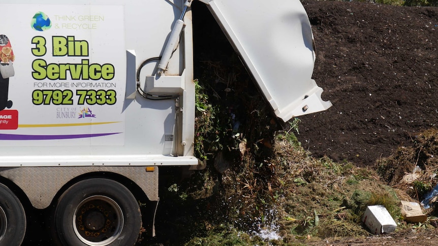 A rubbish truck dumps organic waste
