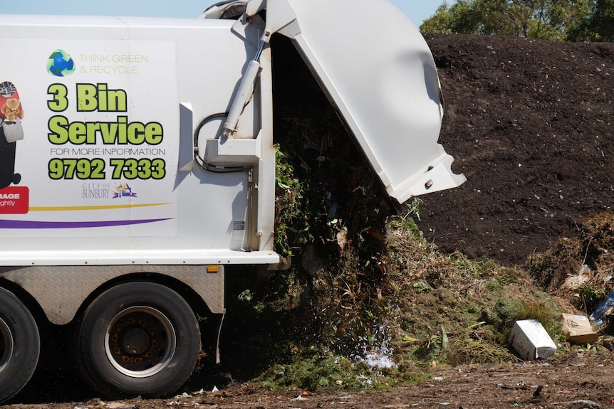 A rubbish truck dumps organic waste