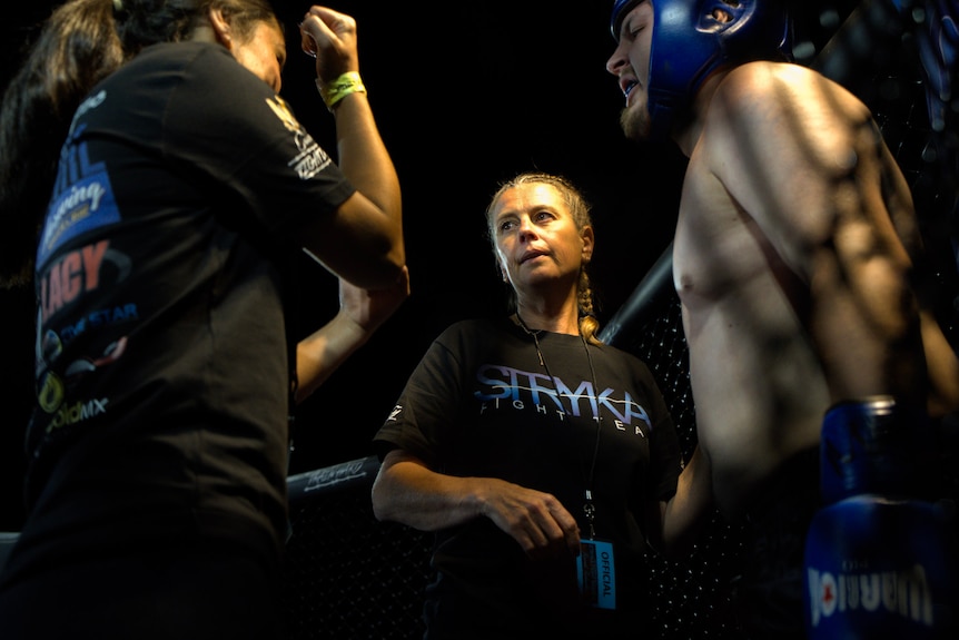 Woman with blonde hair in a boxing ring at corner time.