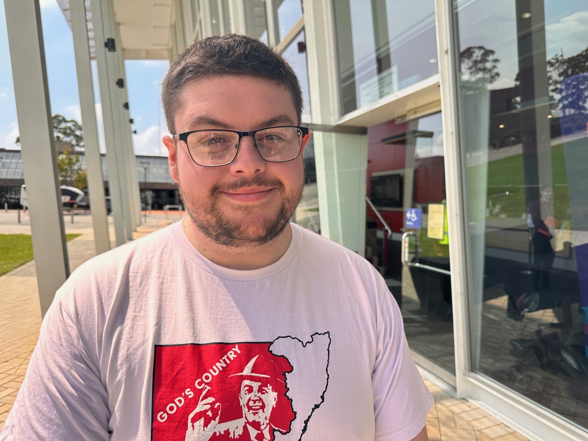 A smiling young man wearing a t-shirt.