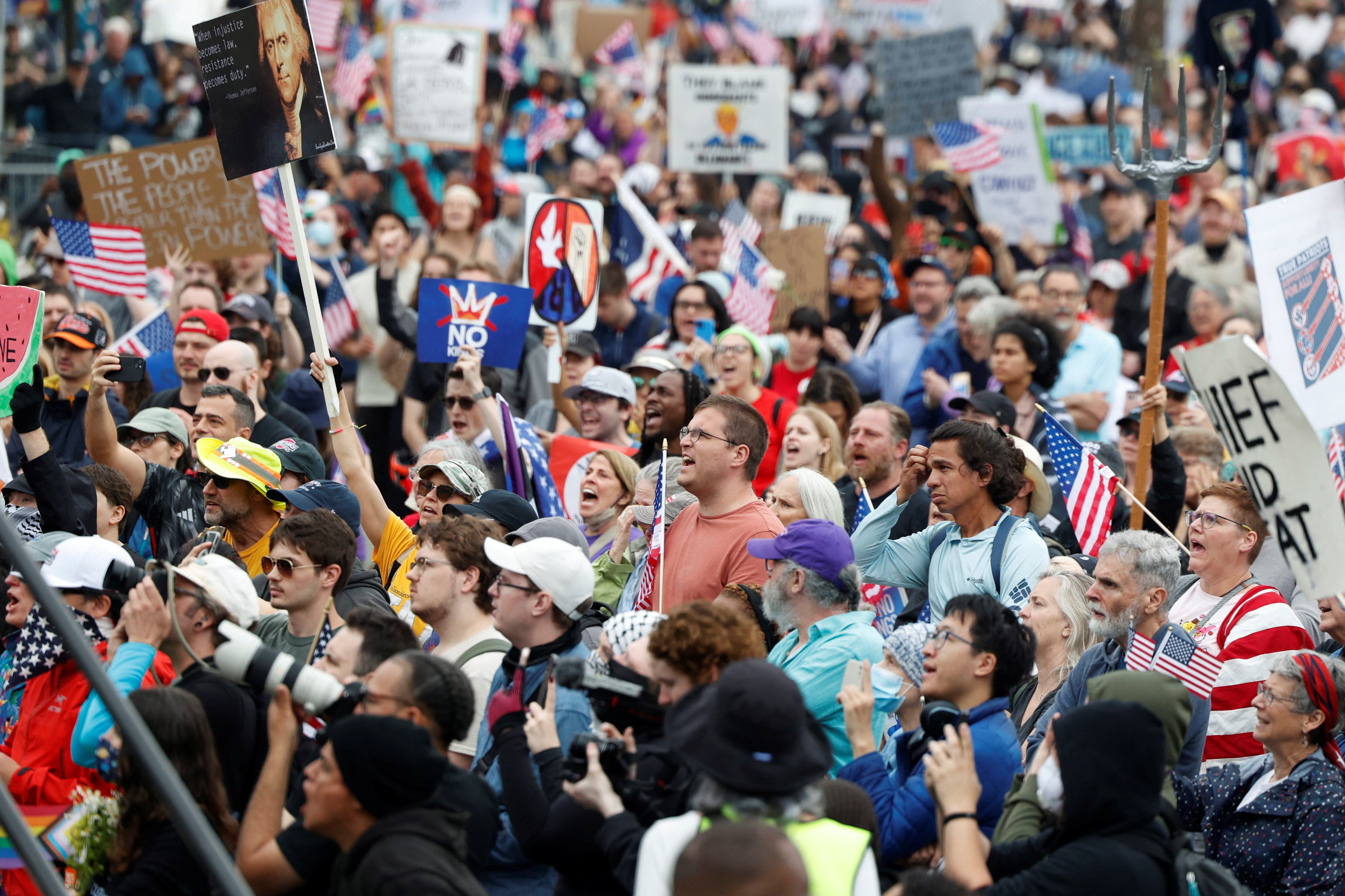 A tightly-packed crowd of protesters hold up placards