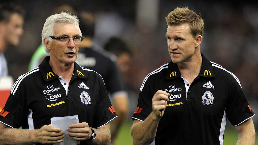 Two members of the Collingwood coaching staff in discussion on the ground at Docklands.