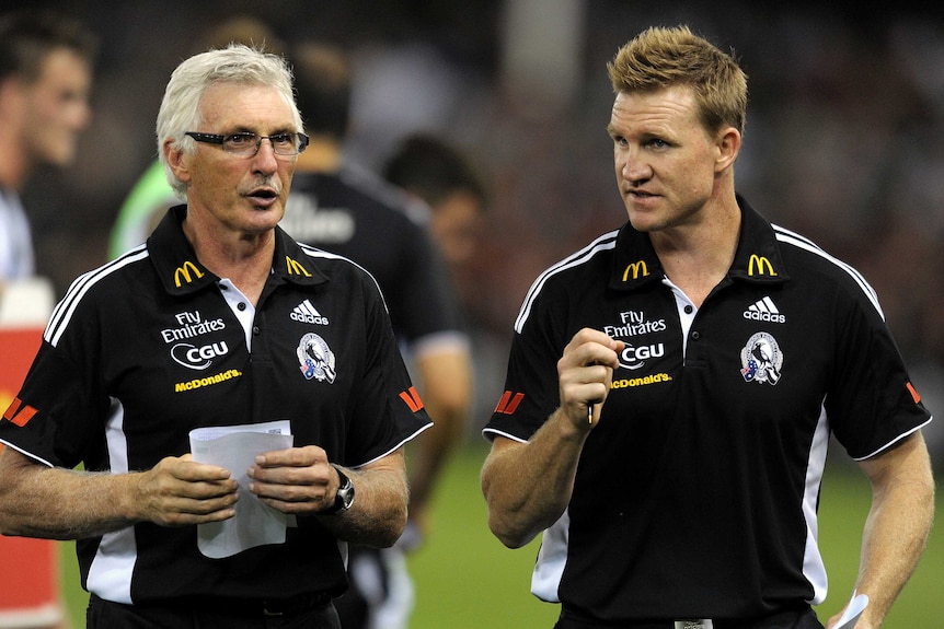 Dos miembros del cuerpo técnico de Collingwood discutiendo sobre el terreno en Docklands.