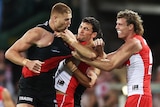 Swans players wrestle with Bombers opponent Peter Wright during an AFL match at the SCG.