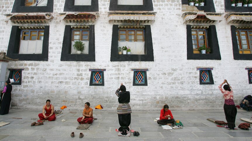 Tibetan pilgrims pray outside Jokhang Temple in Lhasa, Tibet.
