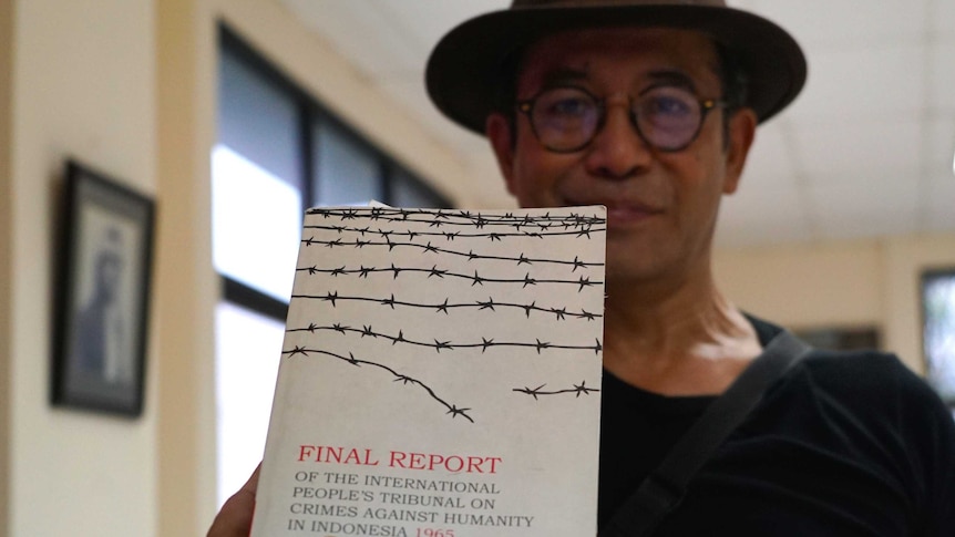 Indonesian activist Reza Muharam holds up a copy of The Hague's report.