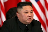 Kim Jong Un listens with an intense stare