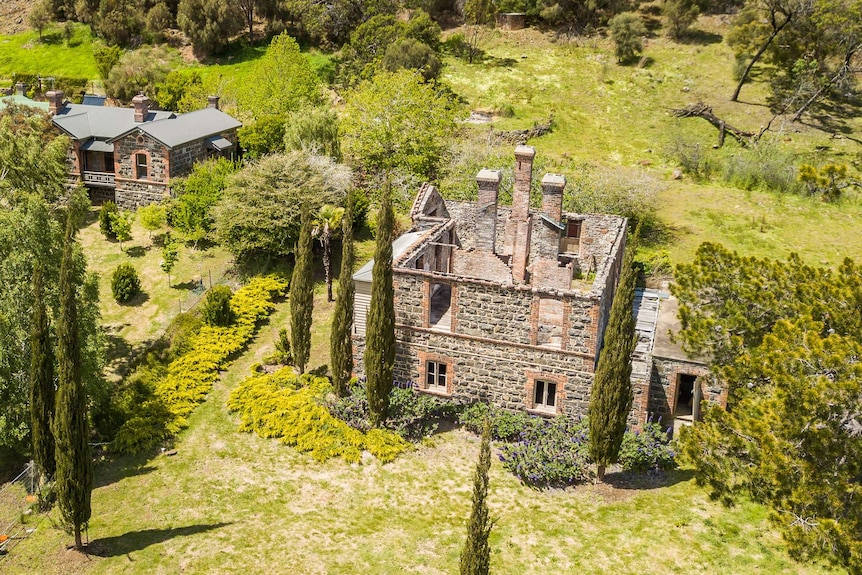 A wide shot of two historic stone buildings surrounded by gardens at Duck Reach in Launceston