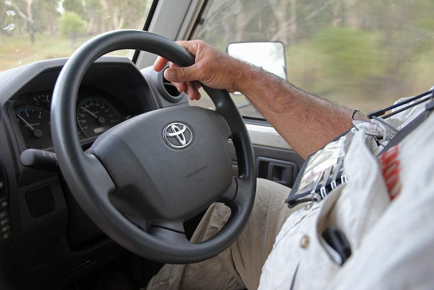 A photo of Gary Lindner's hand on the steering wheel of his ranger vehicle.