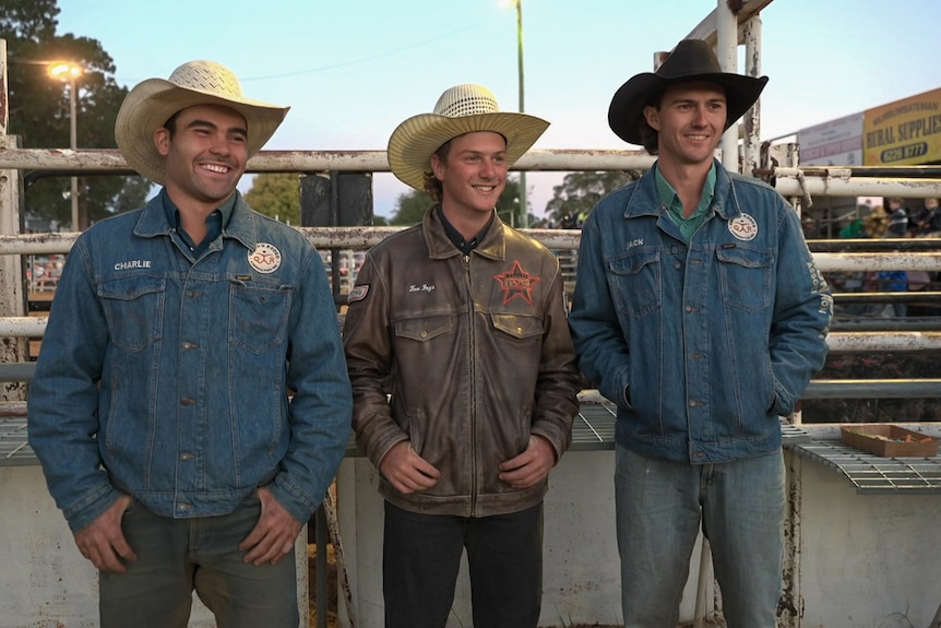 Three men wearing akubra style hats standing in front of cattle yards. 