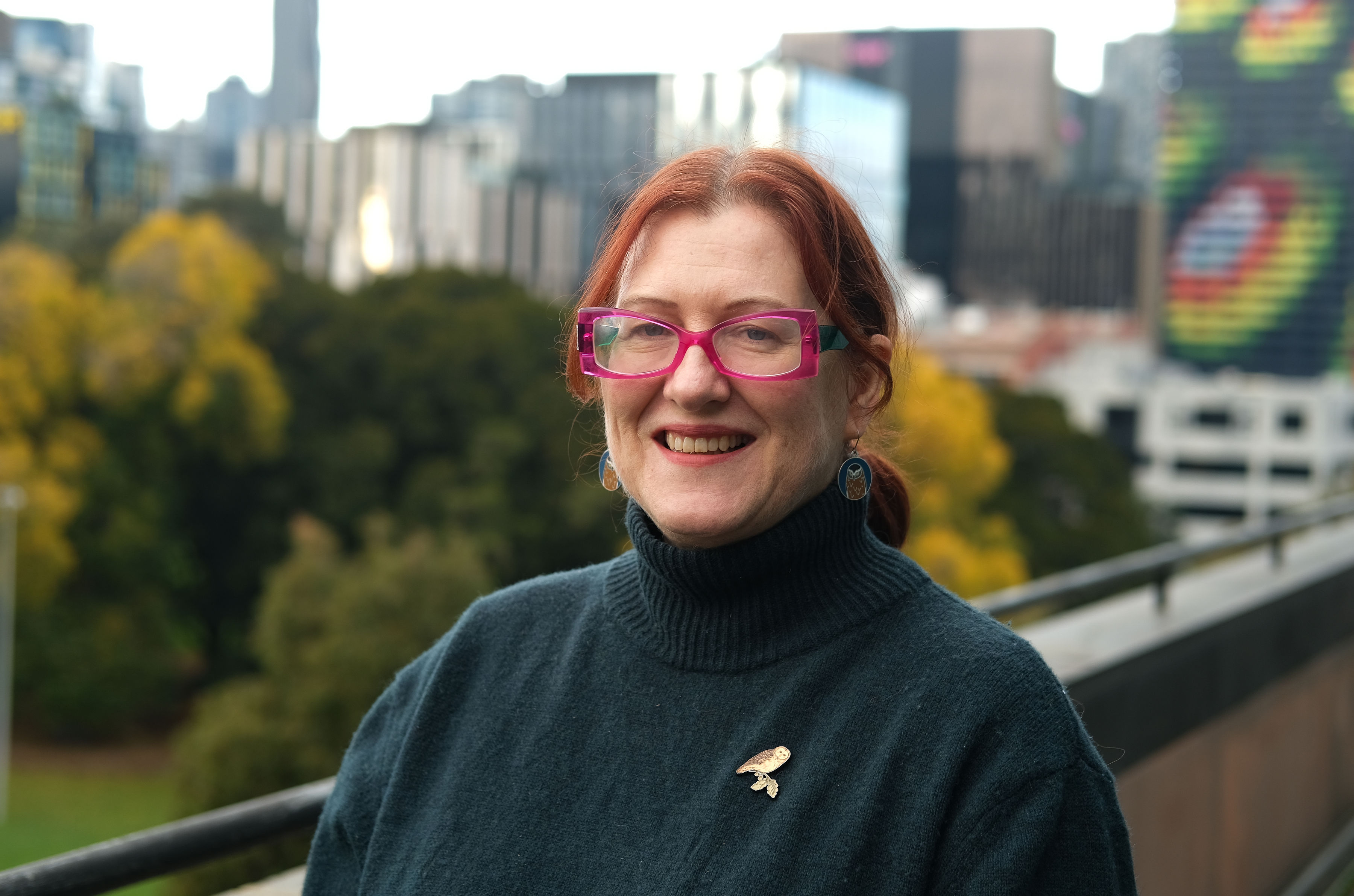 close up of a woman wearing glasses and a navy blue sweater