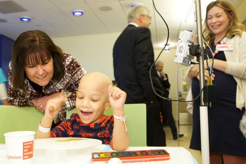 Karen Pence sits with a child who is receiving medical treatment and alternative art therapy treatments at a New York hospital