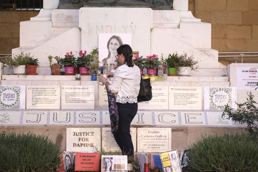 Mandy Mallia, sister of late journalist Daphne Caruana Galizia, lights candles in front of a picture of her sister