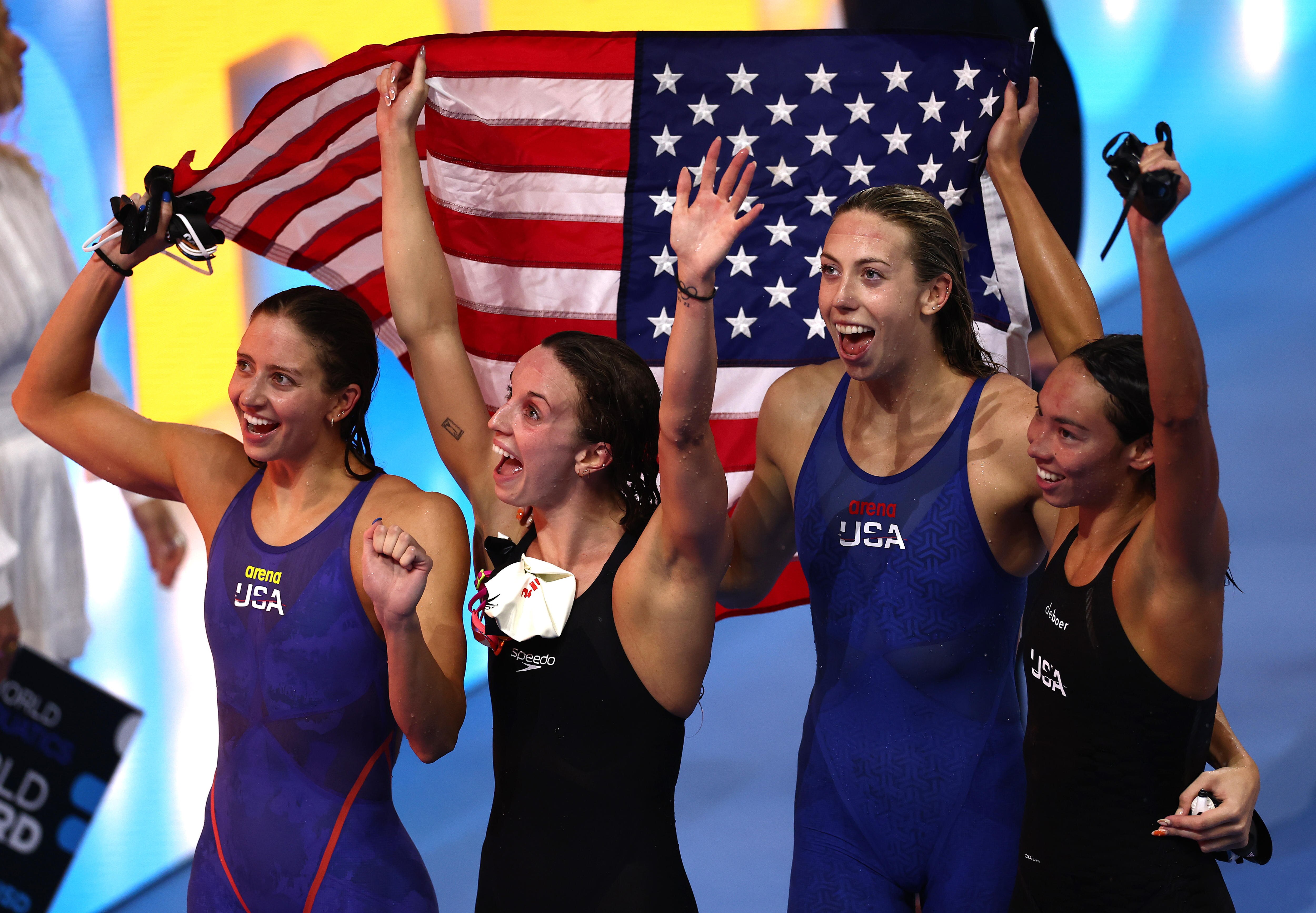 US women's relay team celebrates with flag