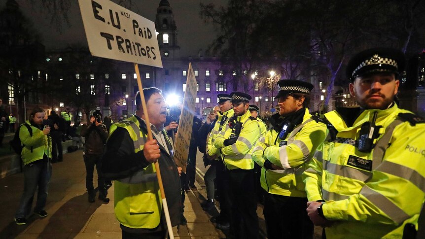 An pro-Brexit demonstrator confronts police officers in Parliament square in London
