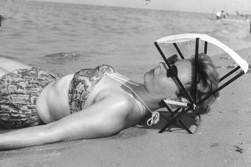 Irene Lee sunbathing, using a sunshade that can also act as a head-rest.