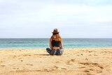 Woman sitting on beach to show one of the benefits of shift work