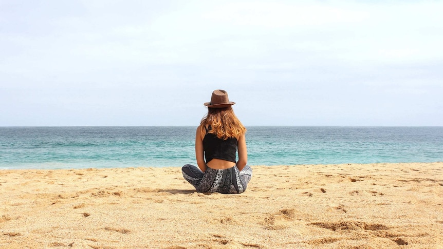 Woman sitting on beach to show one of the benefits of shift work