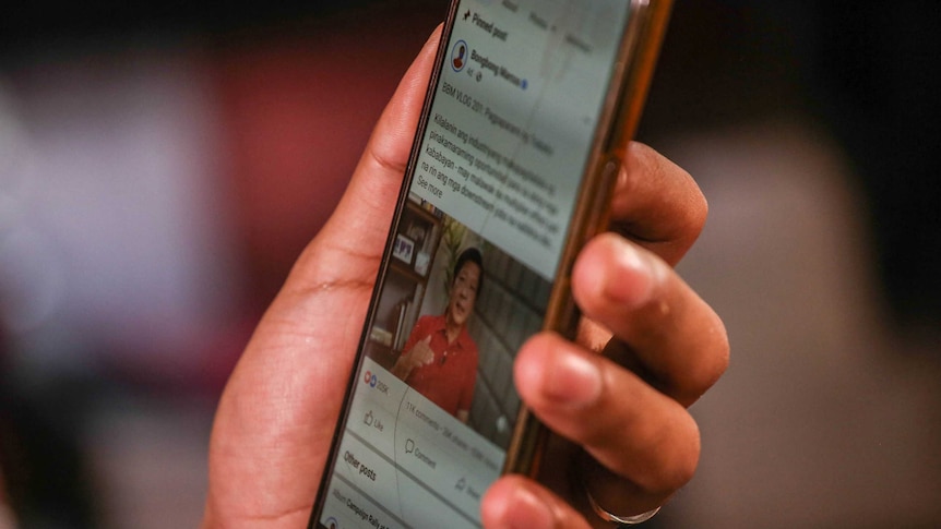 close up image of mobile phone in hand with facebook post of Ferdinand Marcos Jr