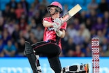Sam Billings hits out while on one knee for the Sixers in their BBL clash with the Hurricanes in Hobart.