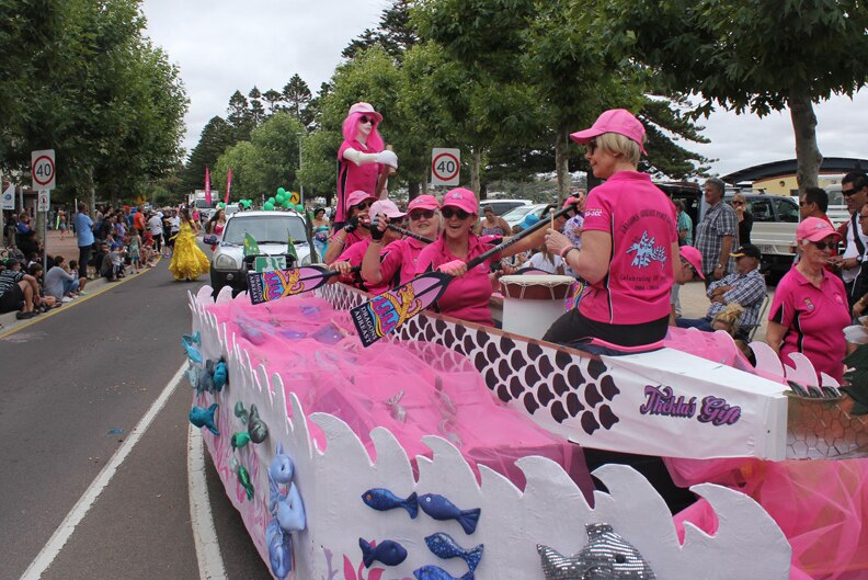 Women in pink pretending to row a boat down the street in Port Lincoln during the 2016 Tunarama festival.