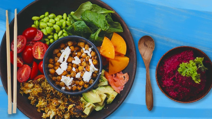 A birds-eye shot of a bright salad, with chickpeas and feta in the middle surrounded by colourful ingredients.