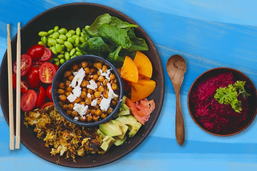 A birds-eye shot of a bright salad, with chickpeas and feta in the middle surrounded by colourful ingredients.