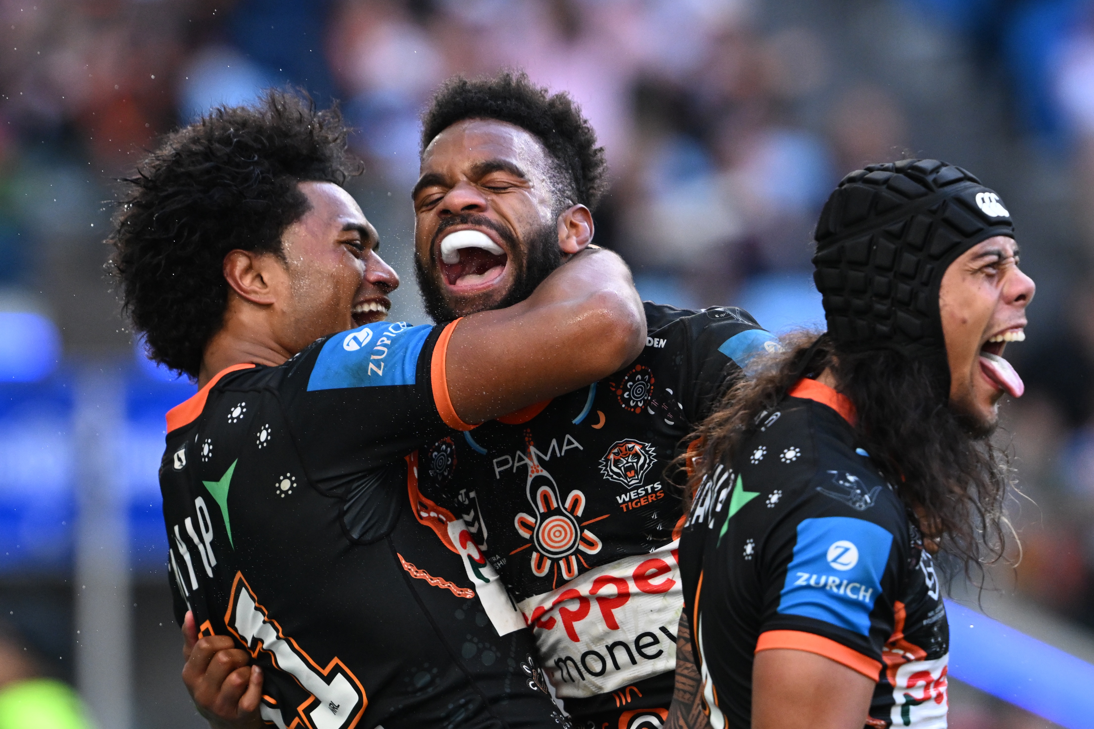 A group of rugby league players celebrate a try