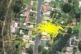 An aerial shot of houses and bushland with jagged yellow lines 'scribbled' on it
