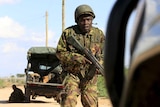 A Kenyan soldier runs for cover near where attackers are holding up a campus in Garissa.
