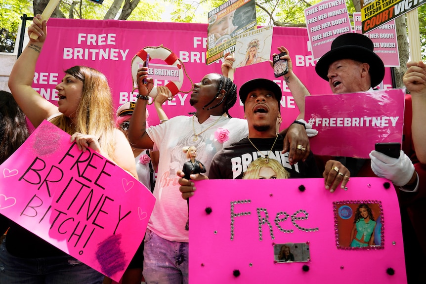 Demonstrators hold pink 'free Britney' signs.