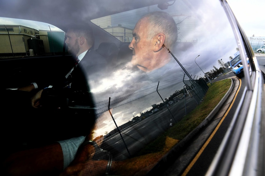 Chris Dawson is seen in a police car on arrival at Gold Coast airport, Thursday, December 6, 2018. 